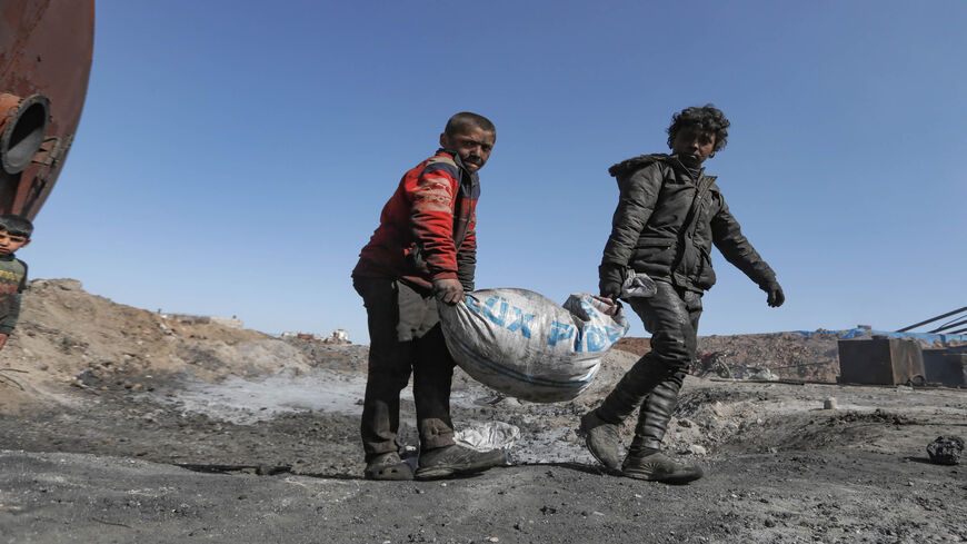 Displaced young Syrian boys work at a makeshift oil refinery near the village of Tarhin in an area under the control of Turkish-backed factions in the northern countryside of Aleppo, Syria, Feb. 25, 2021. 