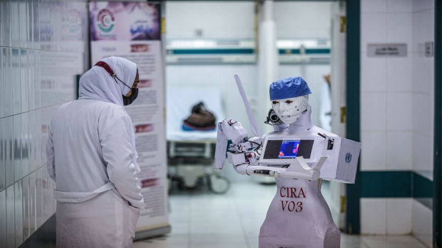 A nurse stands by the CIRA-03 robot prototype built as part of a self-funded project to assist physicians in running tests on suspected COVID-19 coronavirus patients.