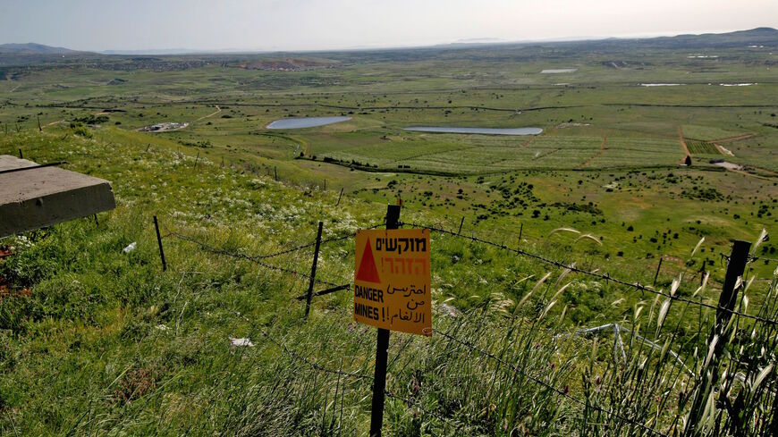 A sign warning against landmines is seen by a barbed-wire fence in the Israeli-annexed Golan Heights on April 22, 2021 near the border fence with the Syrian governorate of Quneitra. 