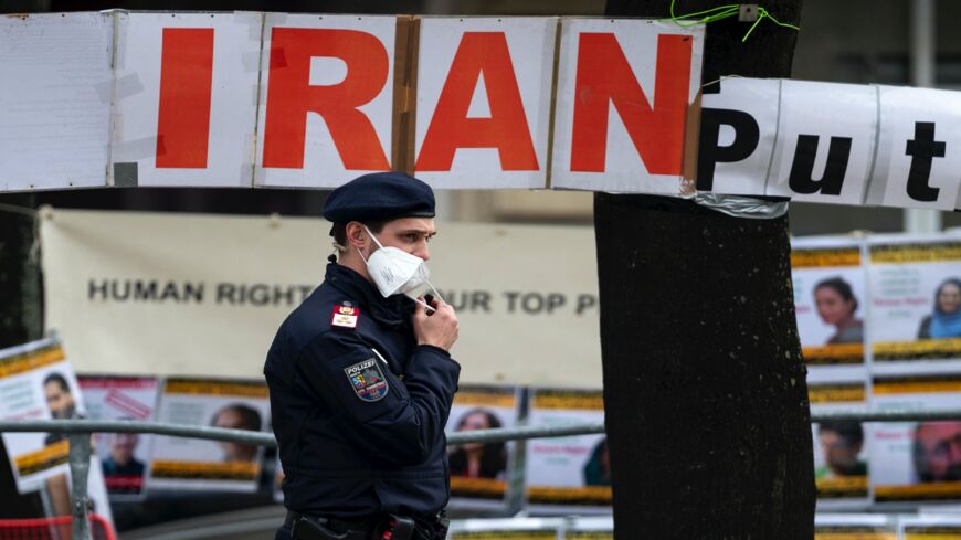 A police officer patrols in front of banners put up by members of the National Council of Resistance of Iran.