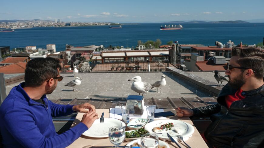 Tourists have a meal at a restaurant at Sultanahmet in Istanbul on May 9, 2021, during a new lockdown aimed at fighting a surging third wave of COVID-19 infections. 