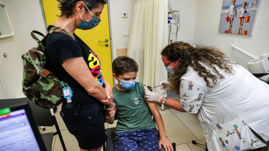 A boy receives a dose of the Pfizer/BioNTech COVID-19 vaccine at the Clalit Healthcare Services in the Israeli city of Holon near Tel Aviv on June 21, 2021.