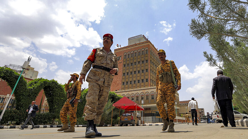 Security personnel loyal to Yemen's Huthi rebels walk about outside the Central Bank headquarters in the Huthi-held capital Sanaa on June 23, 2021. 