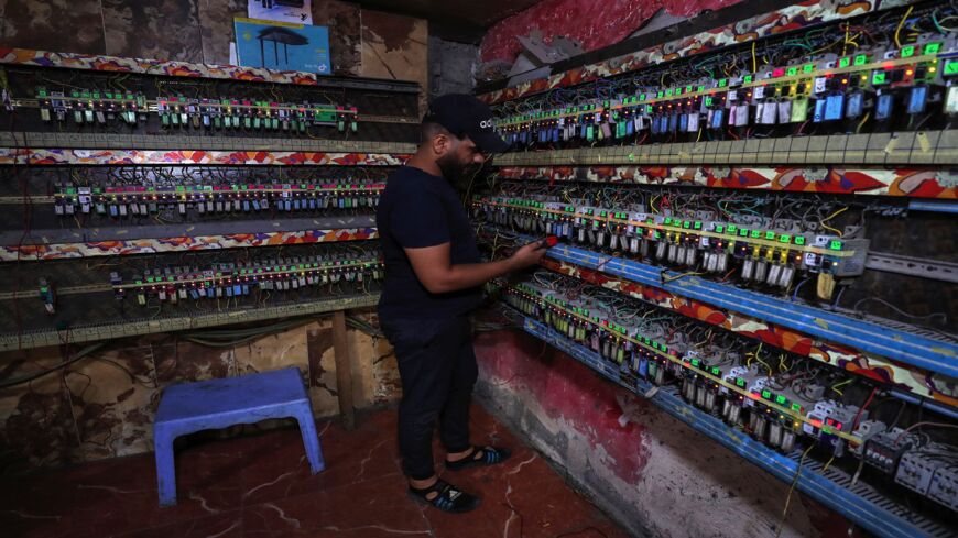 An Iraqi man works at a generator subscription distribution room in Sadr City, east of the capital, Baghdad, on July 2, 2021.
