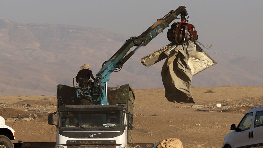 Workers dismantle tents during a demolition operation led by Israeli security forces, of a Palestinian Bedouin encampment in the area of Humsa, east of the village of Tubas in the Jordan Valley, July 7, 2021.