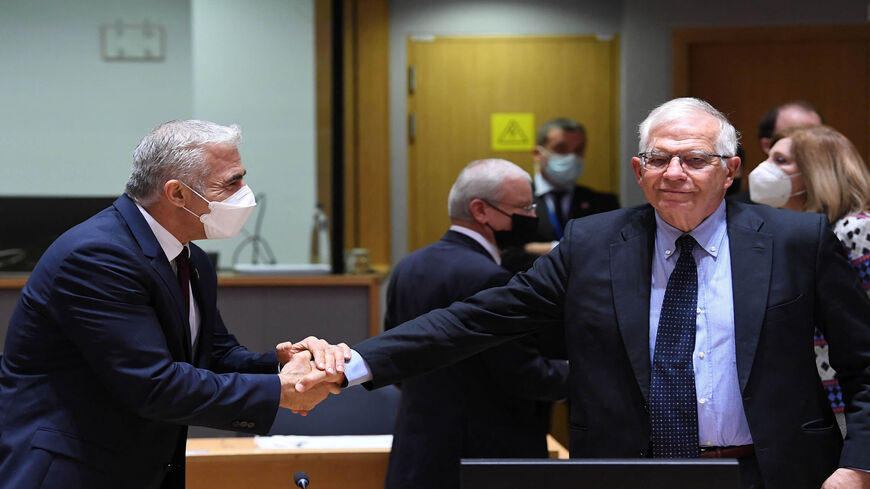Israeli Foreign Minister Yair Lapid (L) shakes hands with European High Representative of the Union for Foreign Affairs, Josep Borrell (R) during a Foreign Affairs Council meeting at the European Union headquarters, Brussels, Belgium, July 12, 2021.