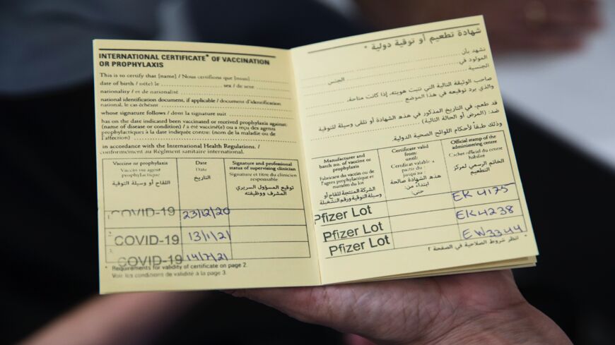 A woman presents a vaccination book with three doses of COVID-19 vaccine recorded at Sheba Medical Center on July 14, 2021, in Ramat Gan, Israel.