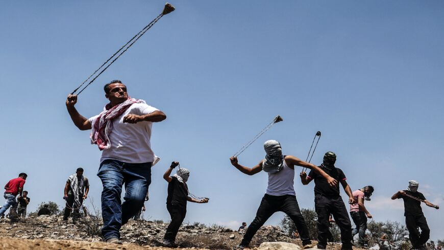 Palestinian protesters hurl rocks at Israeli forces during confrontations with them in the town of Beita.
