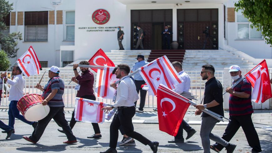 Supporters lift flags of Turkey and the self-declared Turkish Republic of Northern Cyprus.