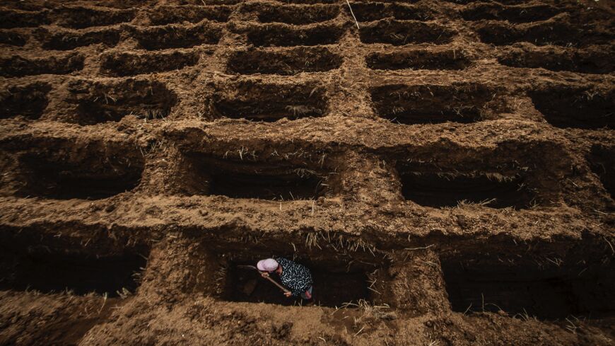 A cemetery worker digs grave holes for victims of the COVID-19 coronavirus at Setu Gede cemetery in Bogor, West Java, Indonesia, on July 22, 2021. 