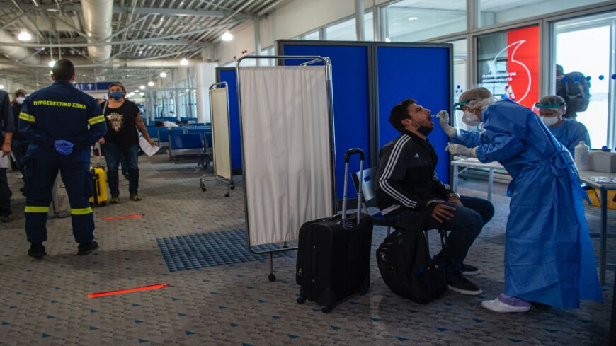 Medical staff conduct a test for the coronavirus on the passengers who arrived from Rome to Eleftherios Venizelos International Airport on June 15, 2020, in Athens, Greece. 