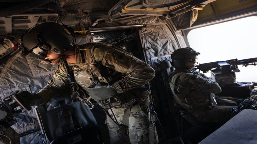 US Army CH-47 Chinook helicopter gunners scan the desert while transporting troops on May 26, 2021, over northeastern Syria. US forces coordinate with the Syrian Democratic Forces (SDF) in combatting residual ISIS extremists.
