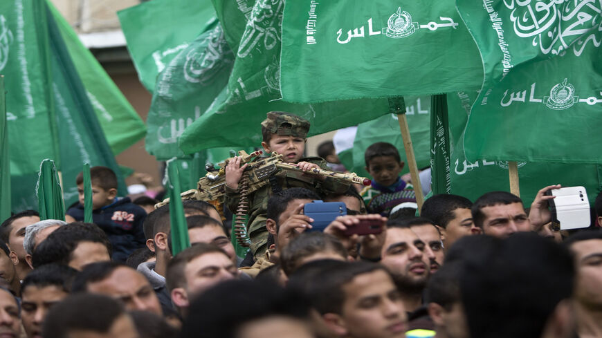 A Palestinian young boy takes part in a rally of Hamas supporters to commemorate the 27th anniversary of the Islamist movement's creation, in Jabaliya refugee camp, Gaza Strip, Dec. 12, 2014.