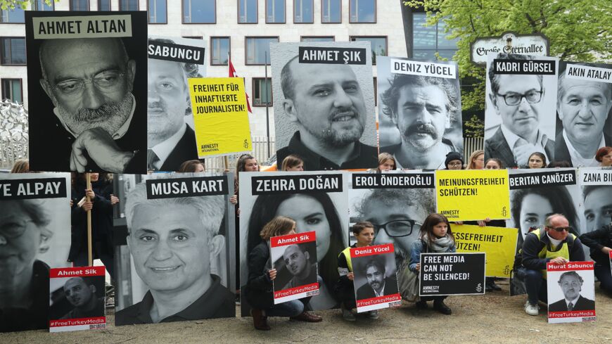 Activists, including supporters of Reporters Without Borders and Amnesty International, hold up the photos of journalists, including Turkish-German journalist Deniz Yuecel, who are currently in prison in Turkey.