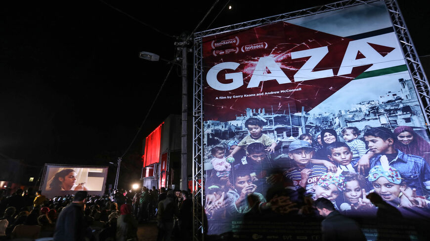 Palestinians watch a film during the opening ceremony of the Red Carpet Human Rights Film Festival in Gaza-Karama Palestine, in front of the abandoned Cinema Amer building in Gaza City, Gaza Strip, Dec. 4, 2019.