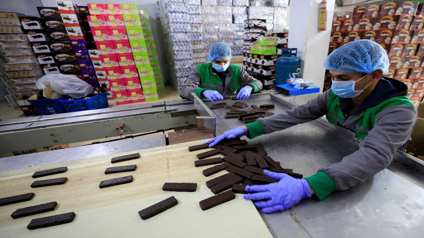 Workers at Al-Arees sweets factory sort a batch of chocolate-covered biscuits in Gaza City, Gaza Strip, Feb. 5, 2020.