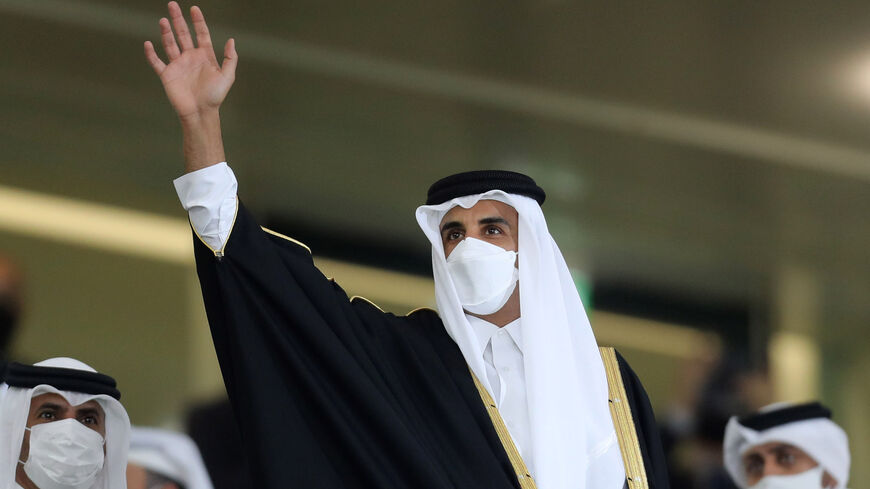 Qatar's Emir Sheikh Tamim bin Hamad al-Thani (C), clad in mask as part of COVID-19 coronavirus pandemic protocols, cheers during the Amir Cup final football match between al-Sadd and al-Arabi at Al-Rayyan Stadium in Al-Rayyan, Qatar, on Dec. 18, 2020. 