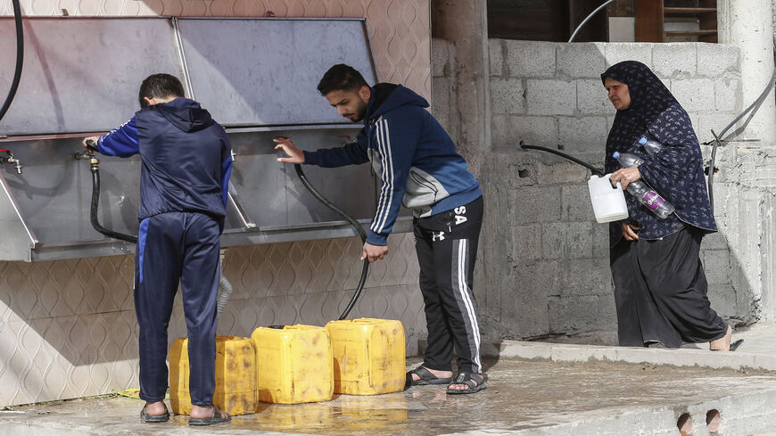 Palestinians fill bottles of water for home consumption at the Rafah refugee camp, southern Gaza Strip, April 8, 2021.