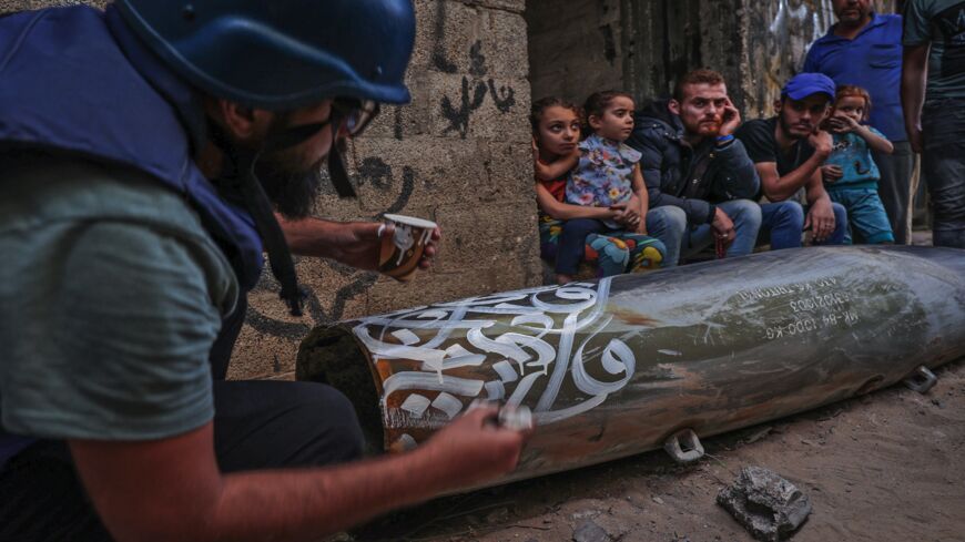 Palestinian artist Bilal Khaled draws on an unexploded device in Gaza City on May 20, 2021.