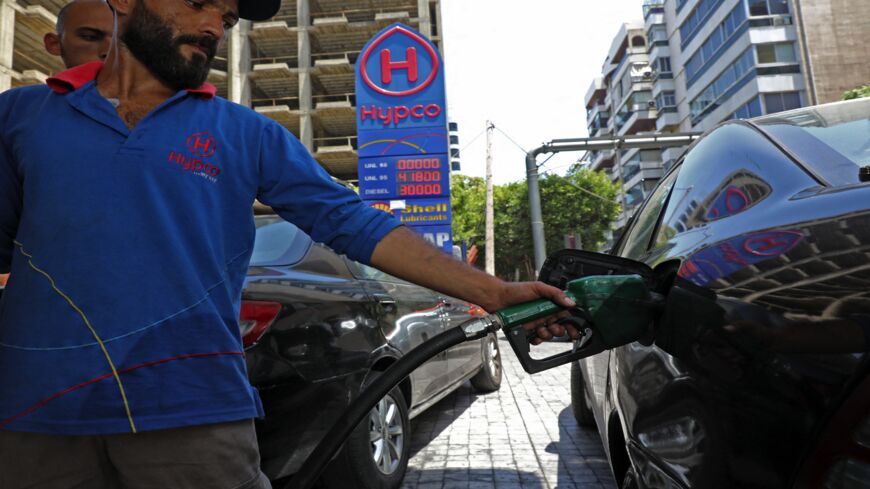 An employee fills a car with gasoline at a petrol station in Lebanon's capital, Beirut, on June 11, 2021, amidst severe fuel shortages. 