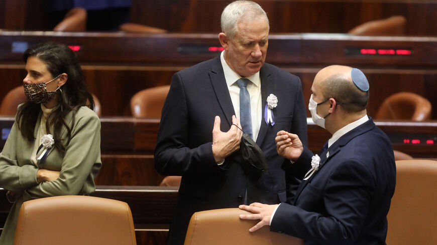 Israel's Defence Minister Benny Gantz (L) and Prime Minister Naftali Bennett speak to each other at a Knesset (parliament) meeting during which Isaac Herzog, a veteran of Israel's left-wing Labor party, was sworn in as the Jewish state's 11th president, replacing Reuvin Rivlin, in Jerusalem, on July 7, 2020. 