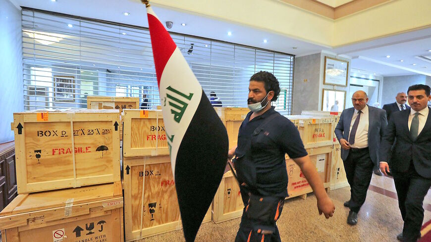 Staff members at Iraq's Ministry of Foreign Affairs work around crates of looted Iraqi antiquities returned by the United States, ahead of a handover ceremony at the ministry in the capital Baghdad, on Aug. 3, 2021. 