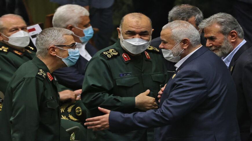 Leader of the Palestinian Hamas movement Ismail Haniyeh (2nd R) shakes hands with Iranian Chief of Staff for the Armed Forces Mohammad Bagheri (L)