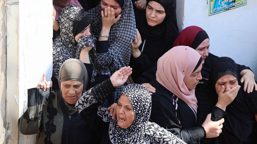The mother (R) of Raed Abu Seif, one of four Palestinians killed in clashes with Israeli security forces earlier in the day, mourns during his funeral in the Jenin refugee camp in the north of the occupied West Bank on Aug. 16, 2021.
