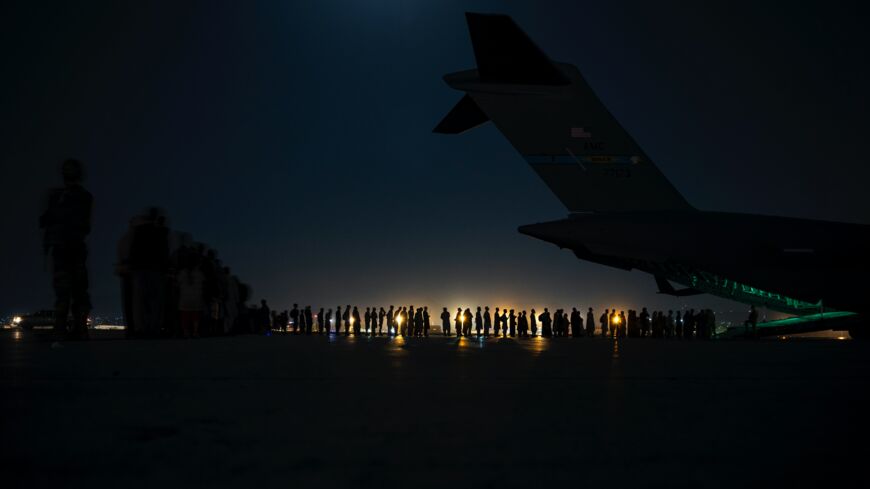 In this handout provided by the US Air Force, an aircrew prepares to load evacuees aboard a C-17 Globemaster III aircraft.