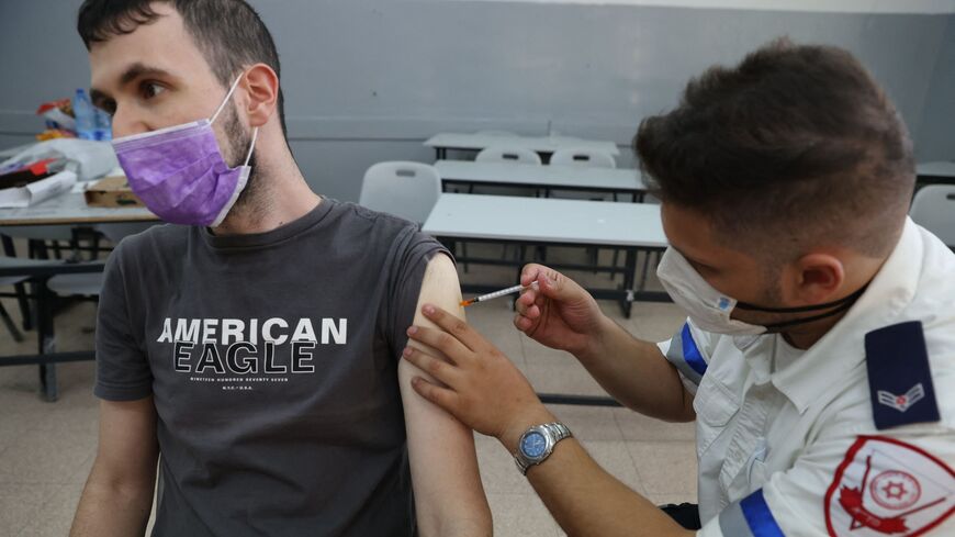 Man receives third shot of the Pfizer COVID-19 vaccine on Aug. 24, 2021, in Holon, Israel.