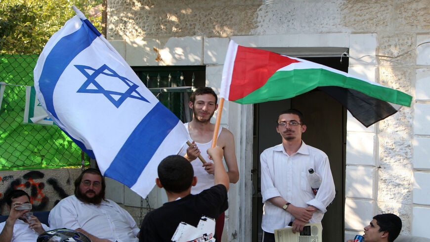 A Palestinian boy waves his national flag in front of the house occupied by settlers belonging to the Palestinian Al-Kurd family, Sheikh Jarrah, East Jerusalem, Sept. 16, 2011.