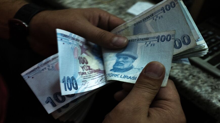 A man counts Turkish Lira at a currency exchange office on July 29, 2020, in Istanbul, Turkey. 
