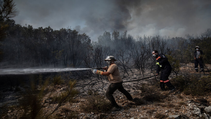 Firefighters battle a large wildfire near the village of Ikizce, in Mugla province, Turkey, Aug. 6, 2021.