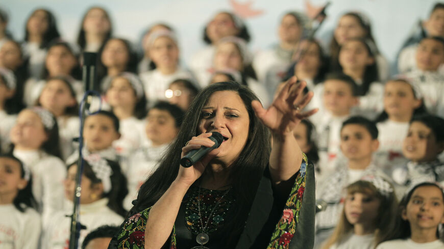 Palestinian singer Reem Talhami from the West Bank sings with choir members, who attend an UNRWA-funded school, during a performance in Gaza City, Gaza Strip, April 23, 2013.