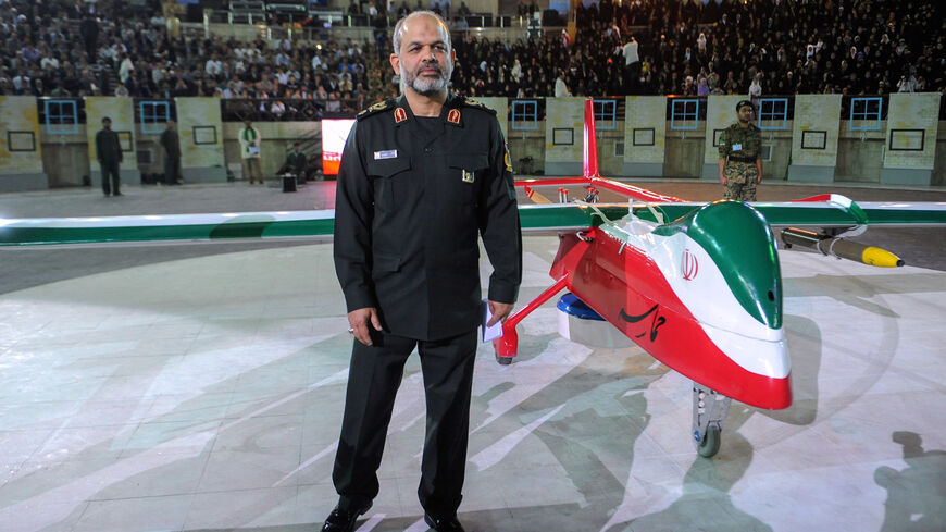 Then-Iranian Defense Minister Ahmad Vahidi stands next to the new Iranian made drone "Epic" during a ceremony in Tehran on May 9, 2013. 