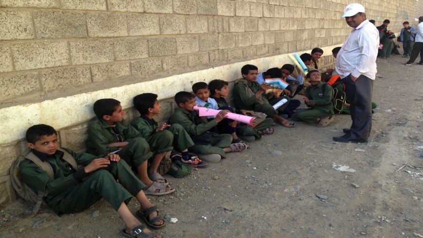 Yemeni school children sit outside their school on Sept. 29, 2014, in the district of Chamlane in northern Sanaa. 