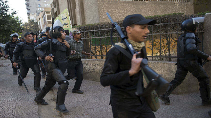 Egyptian riot policemen run after Muslim Brotherhood members following a demonstration in the eastern Nasr City district, Cairo, Egypt, Dec. 27, 2013.