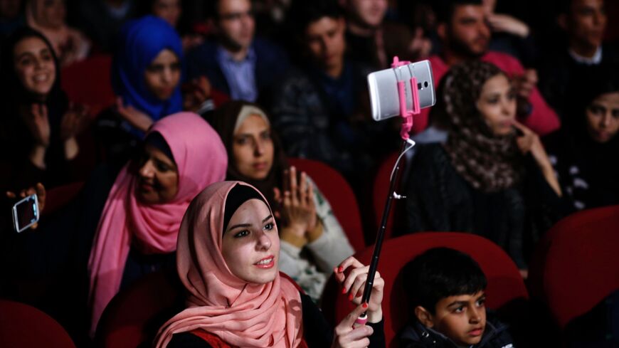 Palestinians watch the group Watar Band perform during a concert in Gaza City on Feb. 25, 2016.