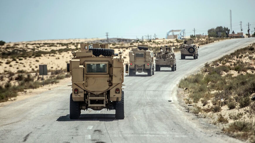 A picture taken on July 26, 2018 shows Egyptian policemen driving on a road leading to the North Sinai provincial capital of El-Arish.  