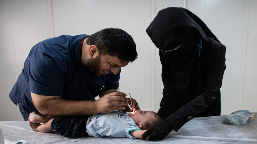 A doctor examines a Syrian refugee baby at the Kahramanmaras refugee camp's hospital, Kahramanmaras, Turkey, Sept. 19, 2019.