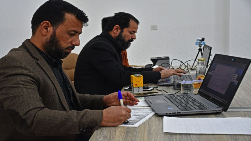 Employees of Iraq's Independent High Electoral Commission Center register voters in the southern Iraqi city of Nasiriyah in the Dhi Qar province, on Jan. 12, 2021. 