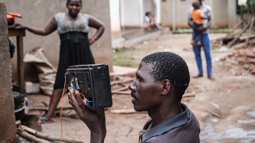 Joseph Kazibwe listens his radio for the final announcement of Presidential election near the home of Presidential candidate Robert Kyagulanyi, aka Bobi Wine, as he stays with his wife in Magere, Uganda, on Jan. 16, 2021.