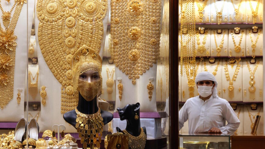A shopkeeper wearing a protective mask amid the COVID-19 pandemic looks out a jewelry shop window displaying intricate pieces for women at the Dubai Gold Souk in the Gulf emirate, on March 10, 2021.