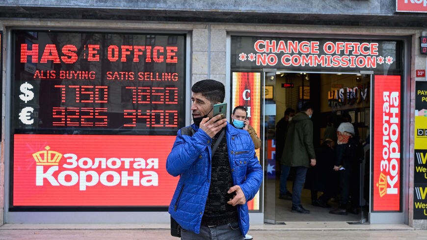 People stand in front of a exchange office at Laleli in Istanbul, on March 22, 2021. 