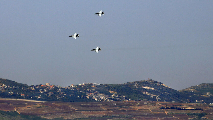 A picture take from the Israeli-annexed Golan Heights shows Israeli Aermacchi M-364 planes performing over Qiryat Shemona near the border with Lebanon (background), during celebrations marking Israel's 73rd Independence Day, April 15, 2021.