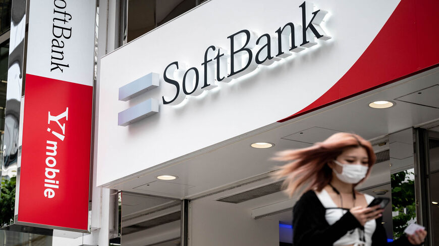 A woman walks past a SoftBank sign, Tokyo, Japan, May 12, 2021.