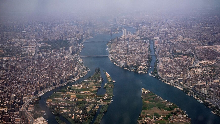 This picture taken on May 14, 2021 shows an aerial view of Egypt's capital Cairo (R) and its twin city of Giza (L), showing the historic old Cairo district (R) and the Nile river islands of (bottom L to R) Qorsaya and Dahab, and the island of Manial al-Roda (C).
