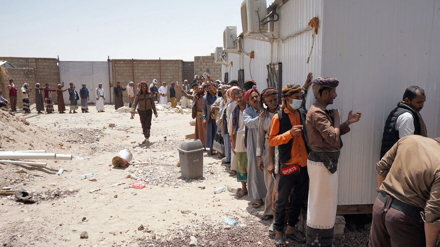 People queue to receive a dose of the Oxford-AstraZeneca COVID-19 coronavirus vaccine at a vaccination center on the outskirts of Yemen's embattled province of Marib in the country's northeast, on July 7, 2021. 