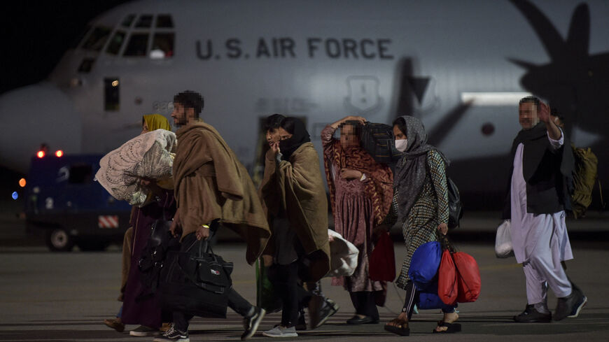 Afghan refugees, fleeing the Afghan capital Kabul, exit an US air force plane upon their arrival at Pristina International airport near Pristina on Aug. 29, 2021.