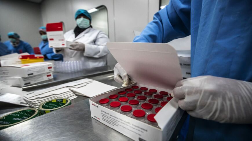 Laboratory workers fill boxes with vials of China's Sinovac vaccine against the coronavirus, produced by the Egyptian company VACSERA, in the capital, Cairo, on Sept. 1, 2021.